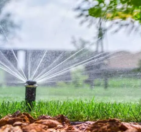 Aspersor pop-up em funcionamento durante irrigação de jardim